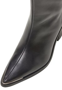 Czarny skórzany botek za kostkę o spiczastym nosku, smukłym designie, gładkiej teksturze oraz subtelnym srebrnym akcentem wzdłuż krawędzi podeszwy.