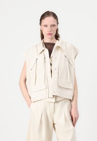 Beige cropped vest van katoenmix, met twee ritszakken, drukknoopjes en korte mouwen, gecombineerd met bijpassende broek.