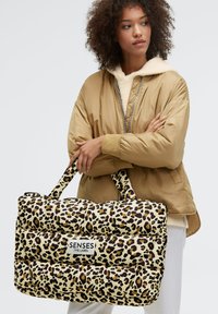 Leopard print padded bag with durable fabric, featuring two handles and a prominent "SENSES THE LABEL" logo on the front.
