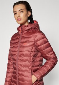 Maroon puffer jacket with horizontal quilting, attached hood, and contrasting orange zipper. Lightweight, smooth texture with logo detail.