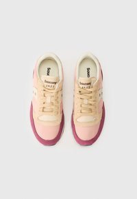 Et par beige, rosa og burgunder Saucony Jazz joggesko med lisser, sett ovenfra på en hvit bakgrunn.