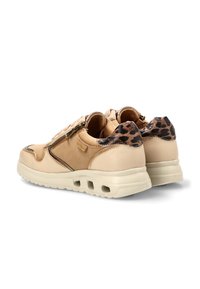 Zapatillas beige con cremalleras laterales, suelas blancas gruesas con orificios de ventilación y detalles de estampado de leopardo en los cuellos de los talones.