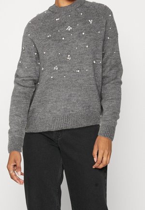 Maglione grigio lavorato a maglia con orlo e polsini a costine, decorato con perle finte sparse e accenti simili a gemme su tutto il tessuto.