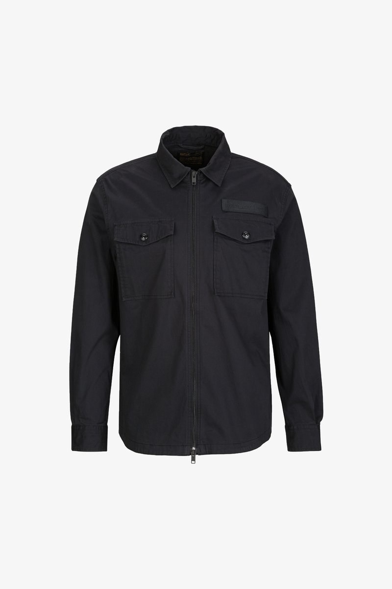 Schwarze Zip-Jacke mit spitzem Kragen, zwei Brusttaschen mit Knopfverschluss und einem strukturierten Etikett auf der oberen linken Seite.