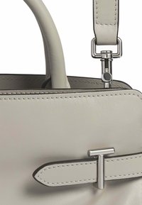 Borsa a mano in pelle grigia con un design strutturato, caratterizzata da una spiccata chiusura in metallo argento a forma di T e dettagli di cucitura a contrasto.