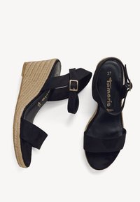 Sandales compensées espadrilles noires avec une finition en daim, comprenant deux brides et une boucle à la cheville, et une semelle plateforme enveloppée de corde texturée.