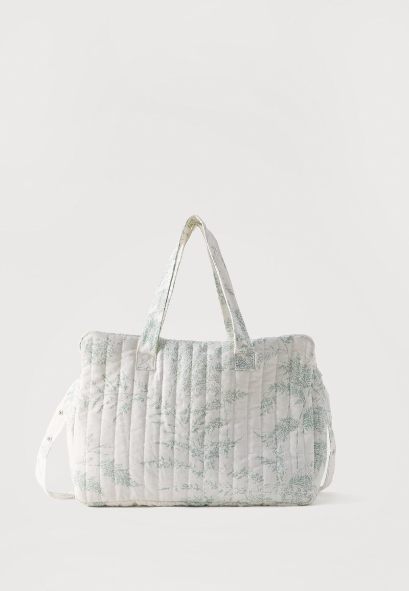 Valgel põimitud duffelkott helerohelise botaanilise mustriga, lühikeste kaheksa käepidemega ja reguleeritava küljerihmaga tavalise tausta peal.