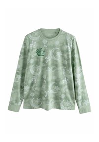 Light green long-sleeve shirt featuring white crescent moons, stars, lanterns, and Arabic text, made from soft fabric with a textured pattern.