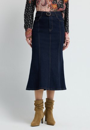 Donkerdenim midi-rok met een uitlopende zoom, vijf zakken en een riemlus. Gepaard met slouchy tan suède hoge hakkenlaarzen.