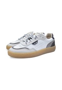 Sneaker basse bianche e grigie con suole in gomma testurizzata, lacci in bianco e nero e tag con il logo "druud" nero sui lati.