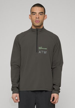 Dunkelgrauer Pullover mit halbem Reißverschluss aus strukturiertem Stoff mit grünem und grauem Logodruck auf der Brust. Lange Ärmel und figurbetonter Schnitt.