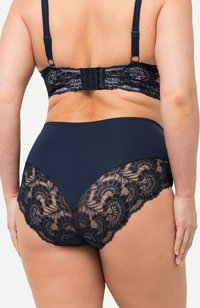 Ensemble de lingerie bleu marine avec un dos en dentelle légèrement texturé et des motifs floraux, associé à un devant en tissu lisse. Bretelles réglables incluses.