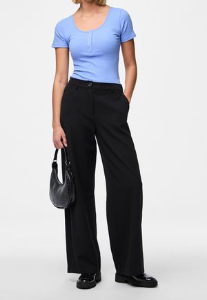 Ljust blå ribbad kortärmad topp med rund halsringning och knappdetalj, kombinerad med högmidjade svarta byxor med vida ben och en svart handväska.