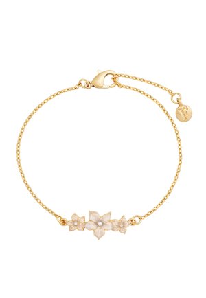 Delikat guldarmbånd med tre hvide emalje blomster i midten og en lille rund vedhæng graveret med bogstavet "F".