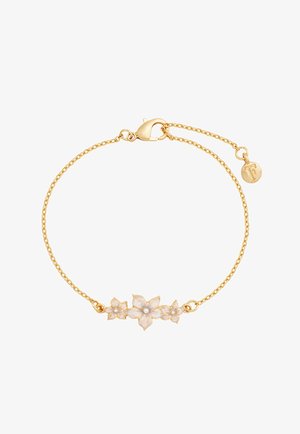 Delicate gouden kettingarmband met drie witte emaille bloemen in het midden en een kleine ronde bedel gegraveerd met de letter "F".