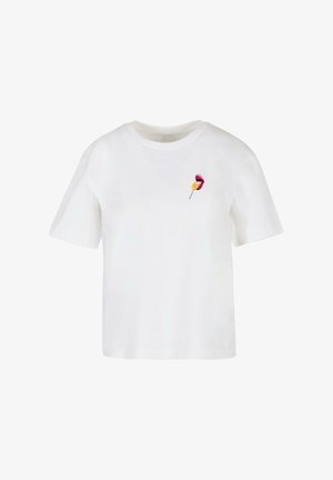 Valkoinen puuvillainen t-paita lyhyillä hihoilla, jossa on pieni graafinen kuva punaisesta vispipuolukasta keltaisella sydämen yksityiskohdalla rinnassa.