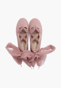 Ballerine rosa con cinturini incrociati e un nastro in tulle abbinato, disposte piatte su uno sfondo bianco.
