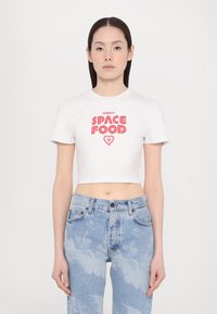 White cropped t-shirt with "Fiorucci SPACE FOOD" red graphic text and heart detail; short sleeves, round neckline, soft fabric texture.
