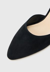 Schwarzer Wildleder-Pumps mit spitz zulaufender Spitze und niedrigem Schaft. Weiche Textur, glatte Innenauskleidung und nahtlose Kantenverarbeitung.