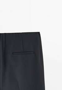 Mustat housut, joissa on sileä pinta, ja joissa on yksi takatasku sekä suora leikkaus. Kankaan näyttää olevan kevyt ja muotoiltu.