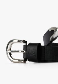 Cinturón de cuero negro con una hebilla de metal plateado. Presenta un diseño de calavera y tibias grabado en el cuero. Textura suave, estilo minimalista.