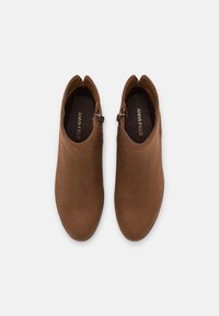 Stivaletti marroni in morbida suede con una finitura liscia, dotati di cerniera laterale e punta rotonda.