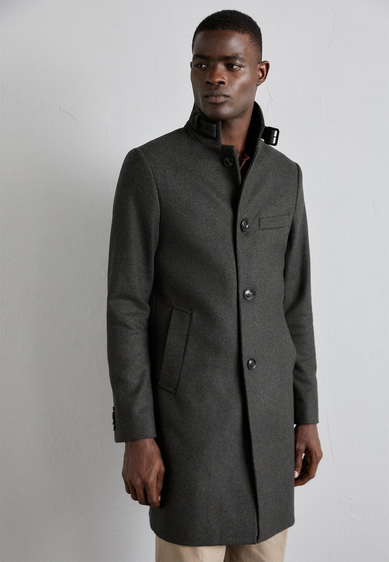 Gray wool coat with a high collar, front buttons, and side pockets. Features a sleek design and a tailored fit.