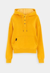 Sudadera amarilla con capucha y un interior acogedor, tres botones de metal en el escote y un bolsillo frontal con una pequeña etiqueta de la marca en el lateral.