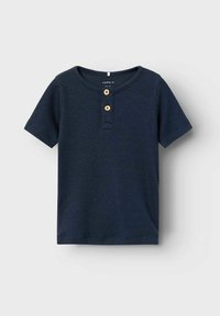 Tumesinise lühikeste varrukatega henley särk ribakangas, millel on ümmargune kaelus ja kaks puitnuppu sanga juures.
