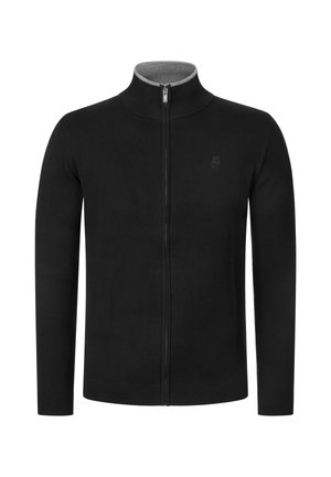 Jersey negro de manga larga con cremallera, cuello alto y un logo sutil en el pecho izquierdo, mostrado sobre un fondo blanco.