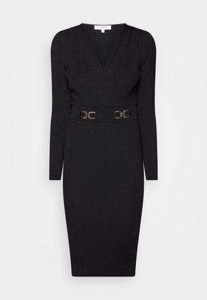 Vestido de punto acanalado negro con escote en V profundo, mangas largas y silueta ajustada. Cuenta con un cinturón negro con detalles en metal dorado.