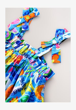 Värikäs kukkakuvioinen mekko, jossa on joustava röyhelöity yläosa ja rusetilla solmittavat olkaimet. Kevyt kangas, jossa on kirkkaat siniset, vaaleanpunaiset ja keltaiset sävyt.