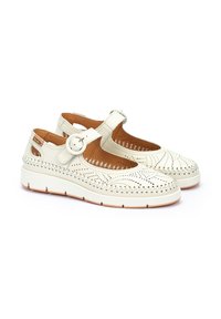 Chaussures blanches en cuir avec un design perforé, bout rond et sangle réglable à boucle. Présentent une semelle intérieure rembourrée et une semelle en caoutchouc.