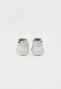 Hvite lær sneakers med flat gummisåle, avrundet tå og jevn tekstur. Inkluderer polstret ankelstøtte og subtil merkevare på hælen.