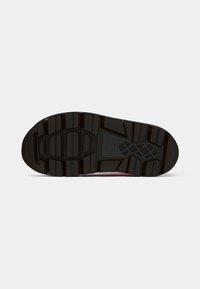 Black rubber shoe sole with deep grooves for traction, featuring a patterned design and rectangular cutouts. Solid, textured surface.
