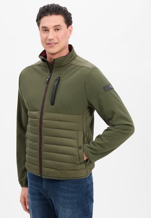 Olivgrüne Jacke mit strukturierter Oberseite und gestepptem unteren Abschnitt, ausgestattet mit einem hohen Kragen, einer geschlossenen Brusttasche und zwei geknöpften Seitentaschen.