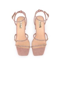 Sandalias de tacón alto de ante en color rosa empolvado con tiras brillantes, diseño de punta abierta y tacón macizo. Incluye correas ajustables en el tobillo.