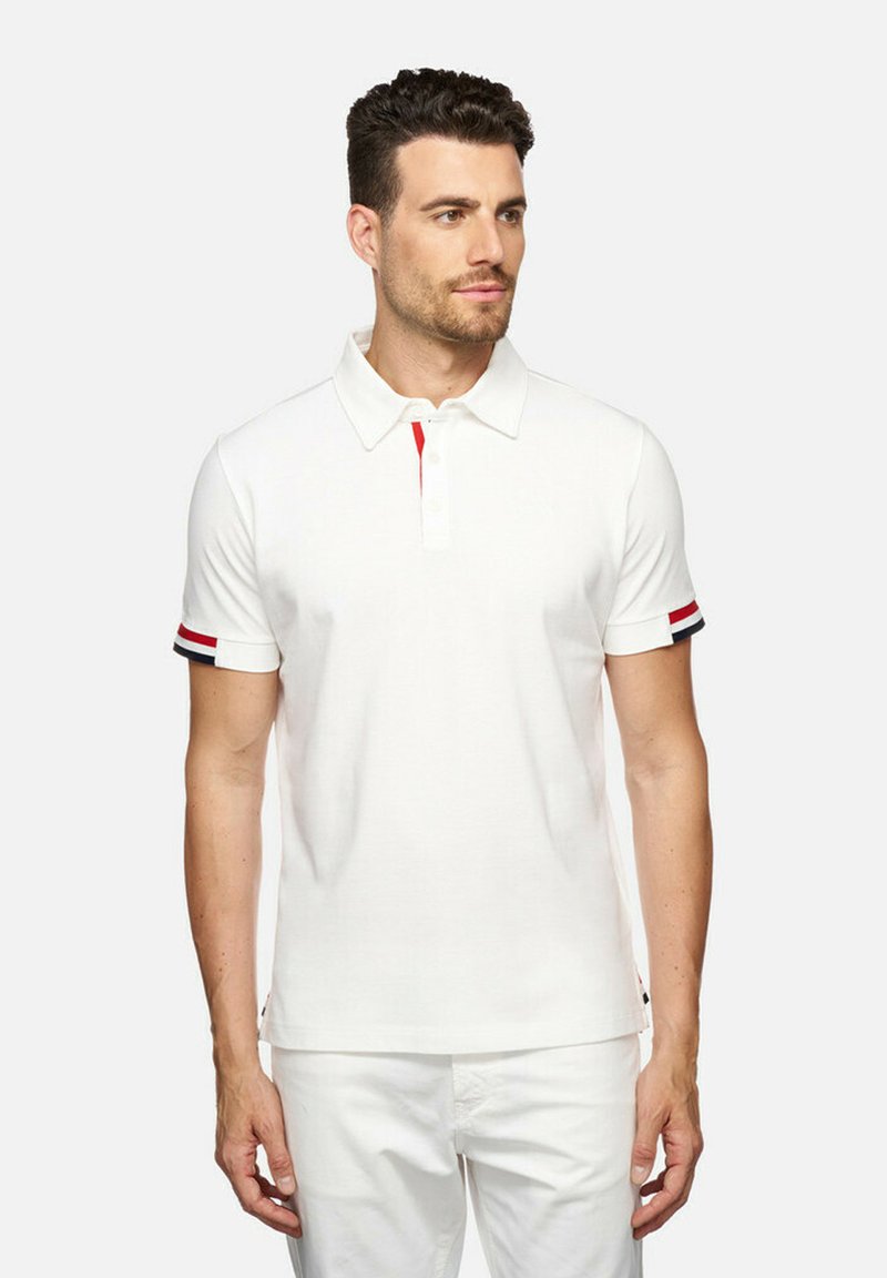 Witte polo shirt met een drieknops sluiting, rode accent onder de kraag en gestreepte manchetten in rood, wit en blauw. Korte mouwen.