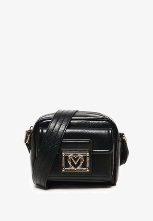Borsa a tracolla in pelle nera con ampia tracolla e placca in metallo dorato sul taschino anteriore, scomparto principale con zip.