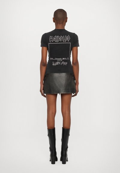 Black short-sleeve t-shirt with graphic prints on the back, paired with a black leather mini skirt and knee-high black boots.