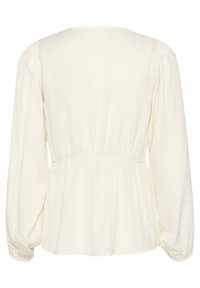 Blusa color crema con maniche lunghe a sbuffo. Presenta un collo rotondo e una vita arricciata, realizzata in un morbido tessuto leggero.