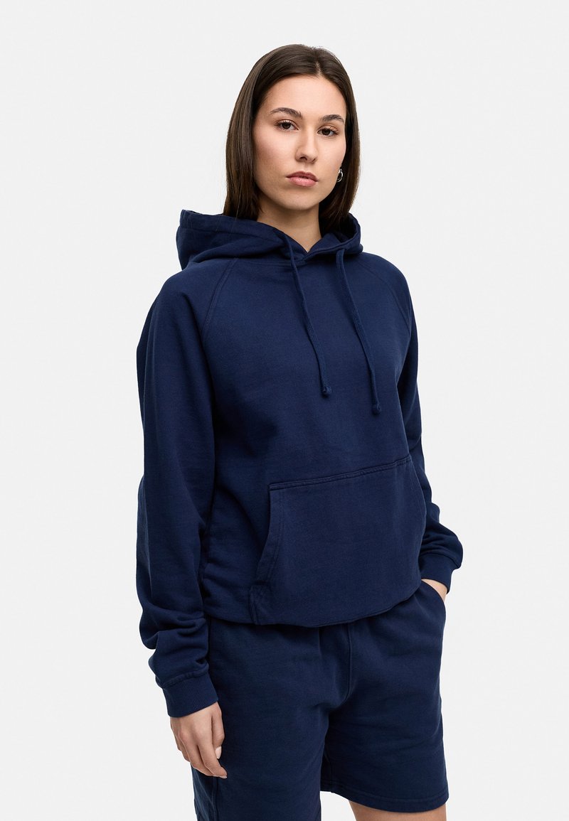 Navy blue hooded sweatshirt made from a soft fabric, featuring a front pocket, drawstring, and ribbed cuffs, paired with matching shorts.