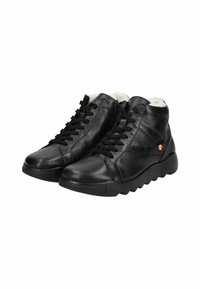 Zapatos de cuero negro de caña alta con un acabado texturizado, que cuentan con un suave forro de piel blanca, cordones negros y una suela de goma con un patrón en forma de ola.