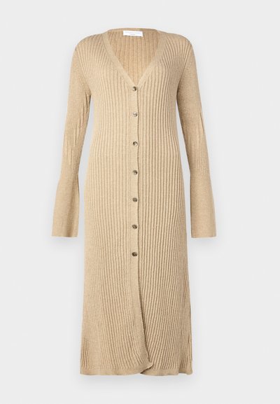 Beige geribde cardigan met lange mouwen, knoopsluiting aan de voorkant, V-hals en uitlopende mouwen. Gemaakt van zacht breimateriaal met een gestructureerde afwerking.