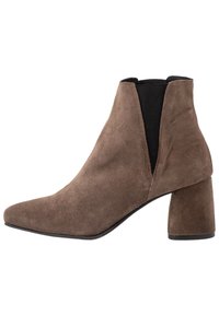 Bottine en daim marron à bout pointu, avec des panneaux latéraux élastiques et un talon épais, présentant une texture lisse et un design minimaliste.