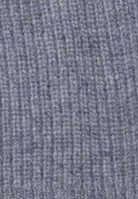Primo piano di un morbido tessuto a maglia a costine di colore grigio chiaro con un aspetto tessuto e lanoso.