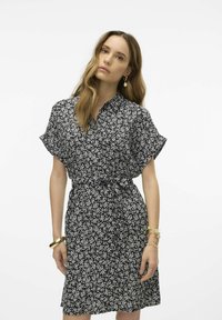 Abito floreale in bianco e nero, maniche corte, stile con bottoni, vita con cintura, tessuto leggero, lunghezza al ginocchio e vestibilità comoda.