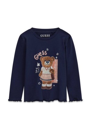 Camiseta azul marino de manga larga con un oso de peluche vestido con uniforme escolar, sosteniendo una bolsa y texto que dice "Guess" y "let's go to school."