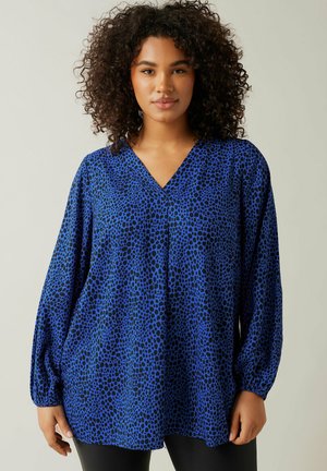 Blusa azul con escote en V, mangas largas y abullonadas, y un patrón de estampado animal negro. Confeccionada en un tejido ligero y de corte relajado.