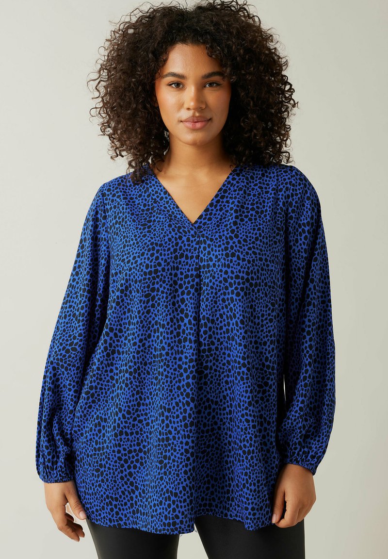 Blusa blu con scollo a V, maniche lunghe a palloncino e un motivo animalier nero. Realizzata in tessuto leggero con una vestibilità comoda.